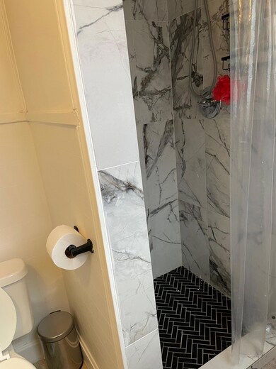 Full bathroom featuring a marble finish shower an