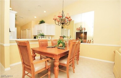 Dining room featuring light tile patterned flooring, lofted ceiling, and a notable chandelier