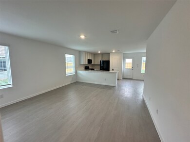 Unfurnished living room with recessed lighting, visible vents, wood finished floors, and baseboards