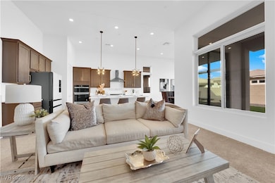 Living room featuring light carpet, a chandelier,