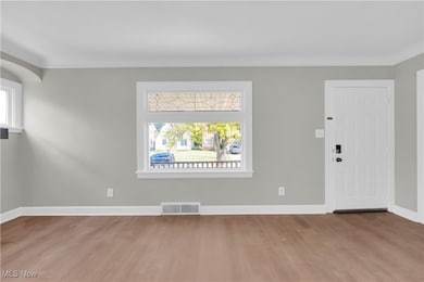 Foyer entrance featuring light wood-style floors and baseboards