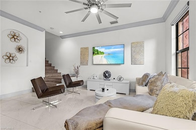 Living room featuring ornamental molding, a ceiling fan, marble finish floors, recessed lighting, and stairs