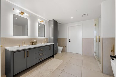 Full bathroom with double vanity, toilet, tile pa