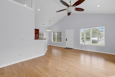 Unfurnished living room with a ceiling fan, healthy amount of natural light, light wood-type flooring, a chandelier, and high vaulted ceiling
