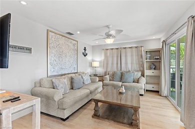 THE SAND UNIT living room with ceiling fan and lig