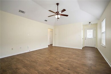 Unfurnished living room featuring ceiling fan, dar