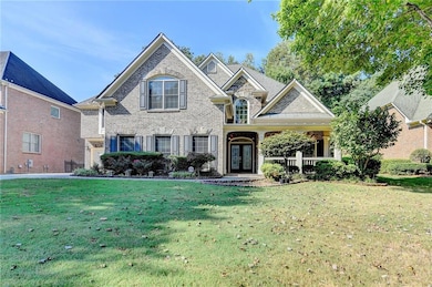 View of front facade featuring brick siding, covered porch, and a front lawn