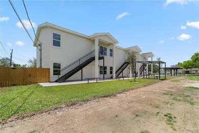 Rear view of property featuring stairway, stucco siding, and a patio area