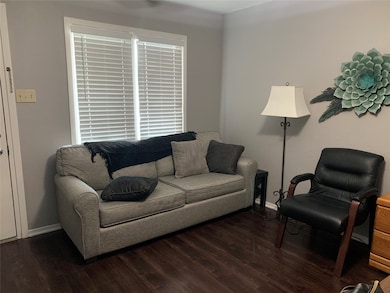 Living room with dark wood-style floors and baseboards