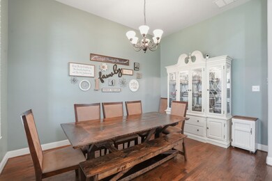 Dining area with dark wood finished floors and a chandelier