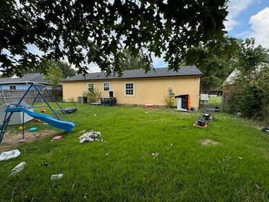 Back of house featuring a lawn and a playground
