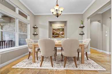 Dining area with ornamental molding and a chandel