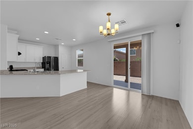 Kitchen featuring a chandelier, light wood-type fl