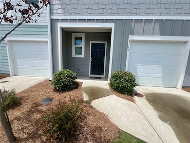 View of exterior entry featuring concrete driveway and board and batten siding