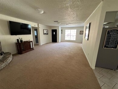 Living room with wooden walls, light carpet, and a