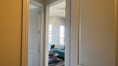 Step into a bright, inviting living area through a charming hallway, where natural light enhances the modern, welcoming ambiance.