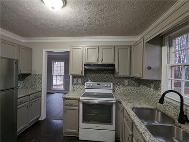 Kitchen with sink, stainless steel refrigerator, white range with electric cooktop, ornamental molding, and backsplash