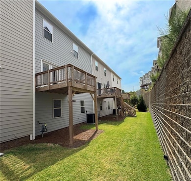 Back of property with a deck, stairs, and a lawn