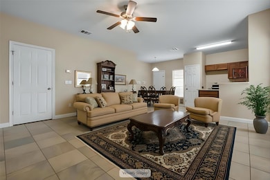 Living area featuring a ceiling fan, baseboards, 