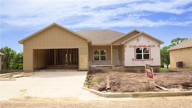 Unfinished property with an attached garage, concrete driveway, and a shingled roof