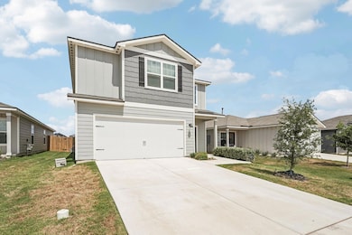 View of front of home featuring board and batten siding, a garage, and concrete driveway