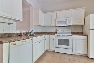 Kitchen featuring white cabinets, white appliances
