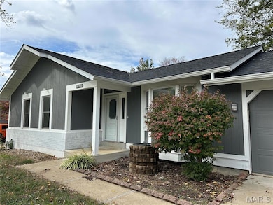 Property entrance with a shingled roof and an attached garage