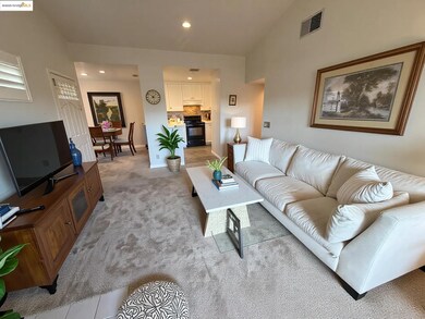 Living area featuring light colored carpet, recessed lighting, and light tile patterned floors