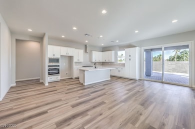 Kitchen with a center island with sink, visible ve