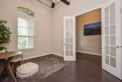 This is the room right off the main entry/foyer, usually used as a study/home office. The beauty of the open floor plan design concept in homes like this, is that the architect has gifted you with space. Now, it's up to YOU to decide how to use it! Huge windows like this provide great natural light. A peek upward displays crown molding and a distinctive tray ceiling.