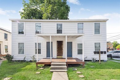 Charming two-story white duplex with a covered cen