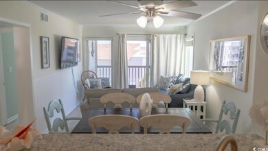Dining room with a ceiling fan, ornamental molding, and a wainscoted wall