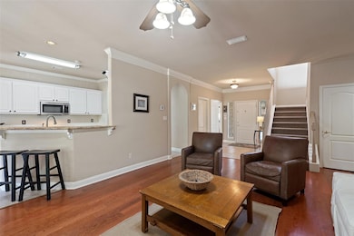 Living room featuring a ceiling fan, wood finishe