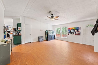 Living room featuring ceiling fan and wood finish