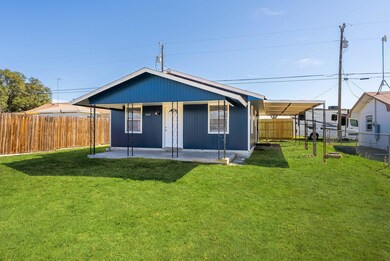 Back of property featuring a yard, a patio, and a