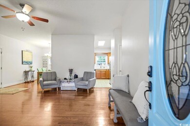 Living room with ceiling fan with notable chandeli