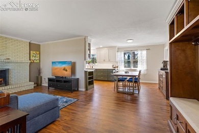 Living room with a fireplace, dark hardwood / wood