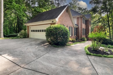 View of side of property featuring brick siding, driveway, and a garage