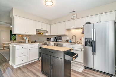 Kitchen with visible vents, a sink, light wood fin
