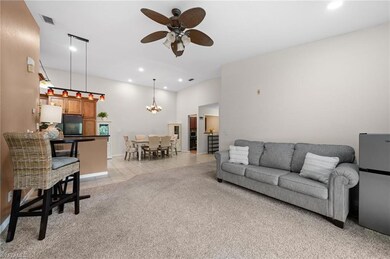 Tiled living room featuring ceiling fan with notab