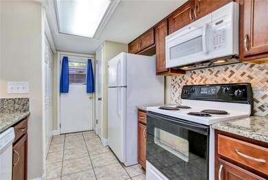 The kitchen features updated appliances, wood cabi