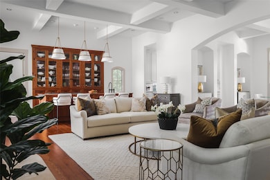 Living area featuring arched walkways, beam ceili