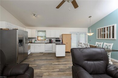Kitchen featuring dark hardwood floors, white cabi