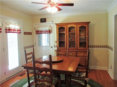 The dining room is big enough for a larger table if needed and china cabinet. It has crown molding, new hardwood (2013), ceiling fan lighting, a patio door and a door to the garage. 