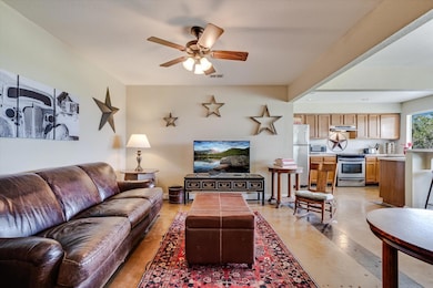 Living area featuring a ceiling fan and concrete 