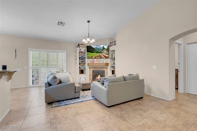 Living area with visible vents, a tiled fireplace,
