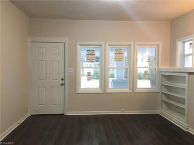 Living room with new flooring, paint, light fixtures, and windows