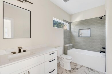 Full bath featuring vanity, marble finish floors,