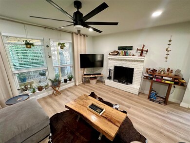Living area with a brick fireplace, ceiling fan, 