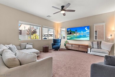 Living area featuring a ceiling fan, carpet floori